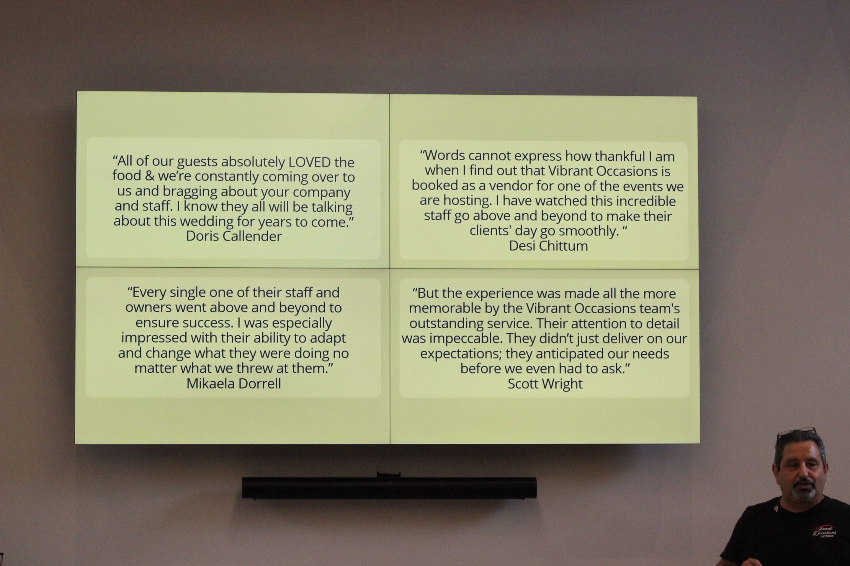 A man stands in front of a screen displaying four positive customer testimonials about Vibrant Occasions, praising their food, service, attention to detail, and adaptability during events.